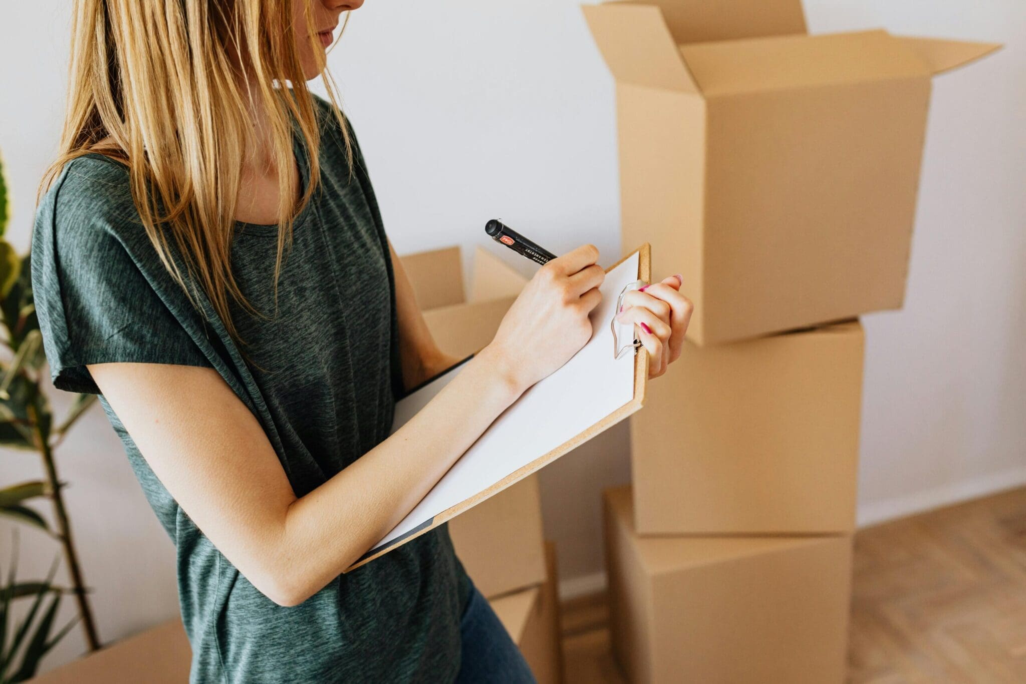 a girl listing a pile of boxes