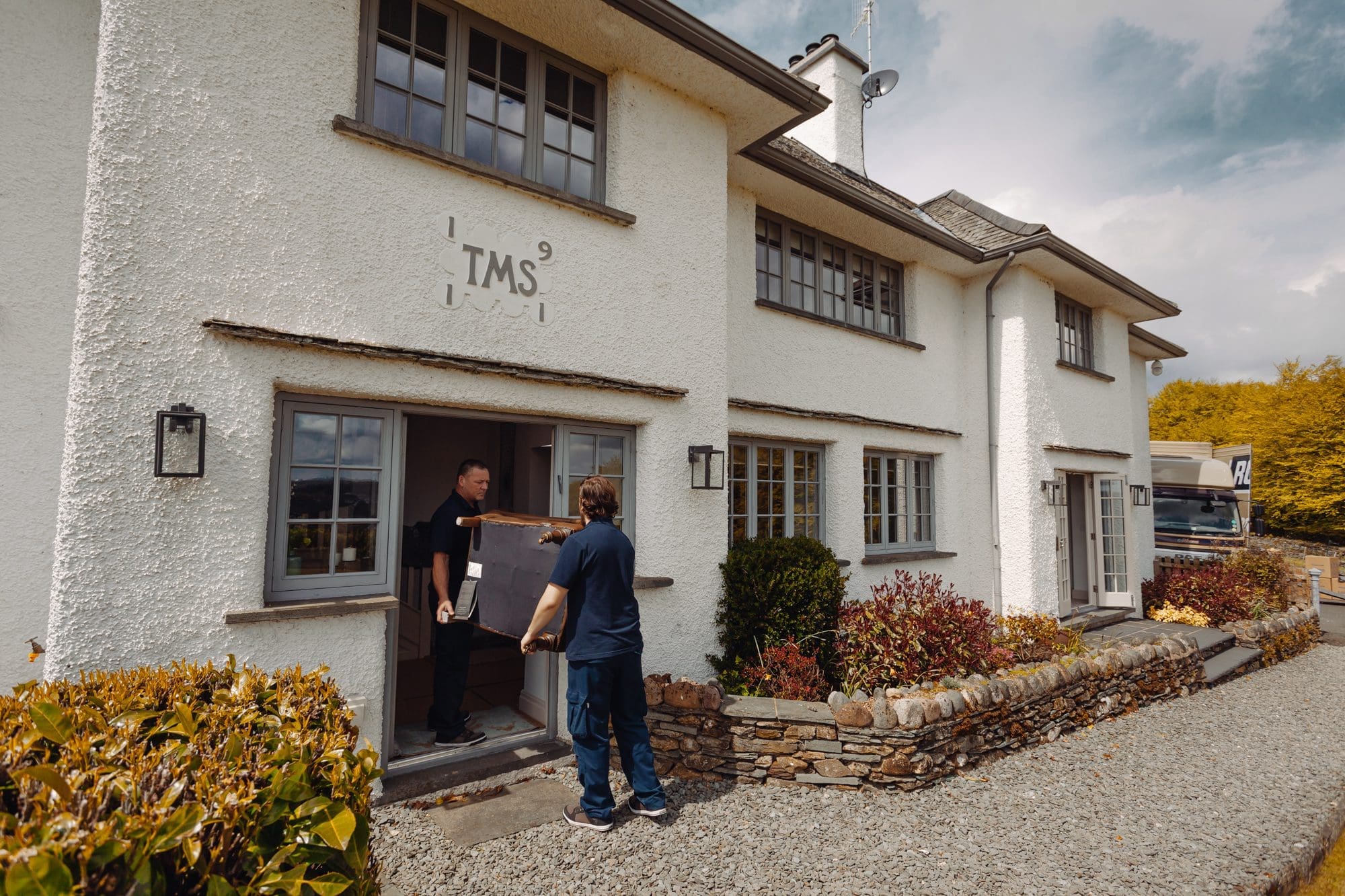 two men carrying a chair